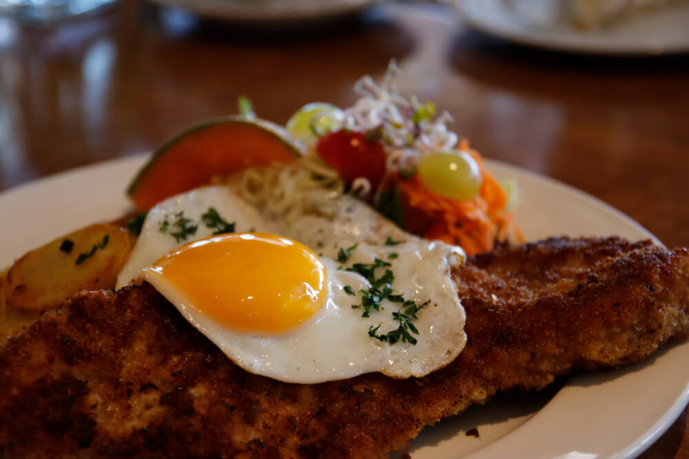 Schnitzel mit Spiegelei, Bratkartoffeln und Gemüsebeilage